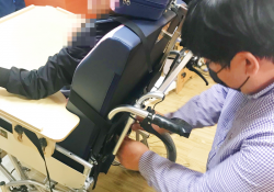 장애아동이 지원받은 휠체어에 앉아 있는 모습입니다