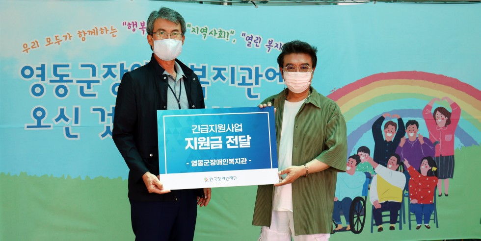 박병규 관장님과 한국장애인재단 이사장님이 긴급지원사업 지원금전달이라는 글자가 새겨져 있는 팻말을 두분이 같이 들고서 기념 촬영을 한 사진입니다.